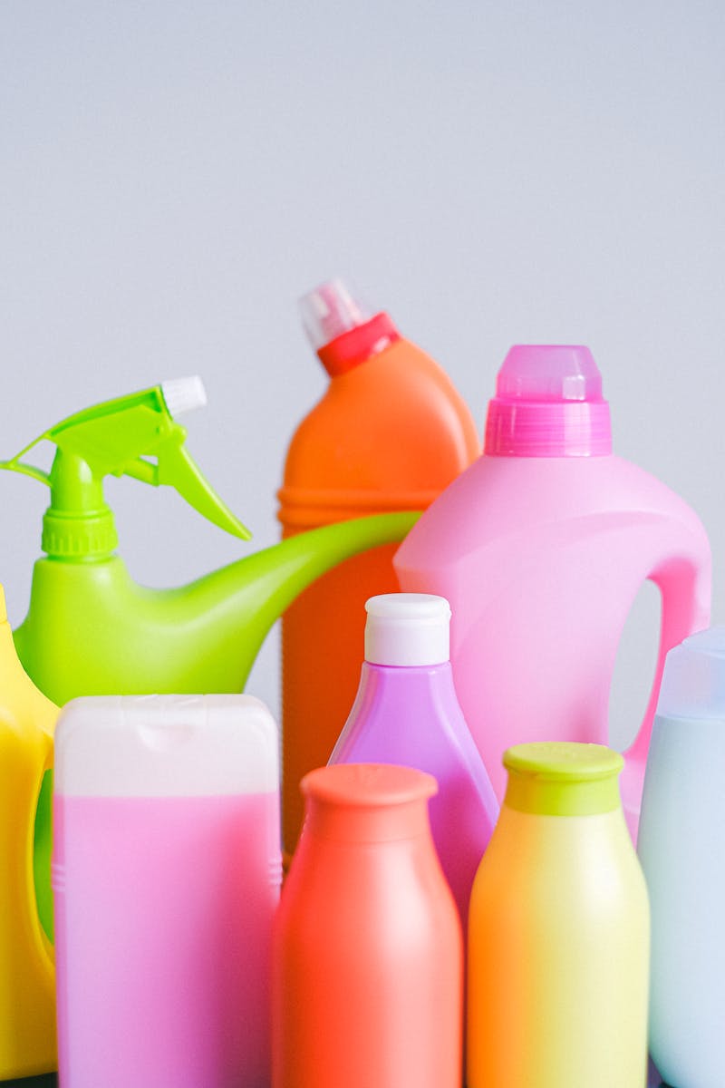 Assorted colorful detergent bottles on a bright white surface.